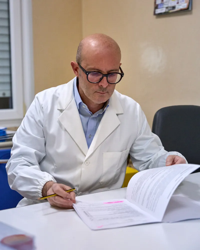 Il Dr. Miele alla scrivania mentre compila una cartella clinica